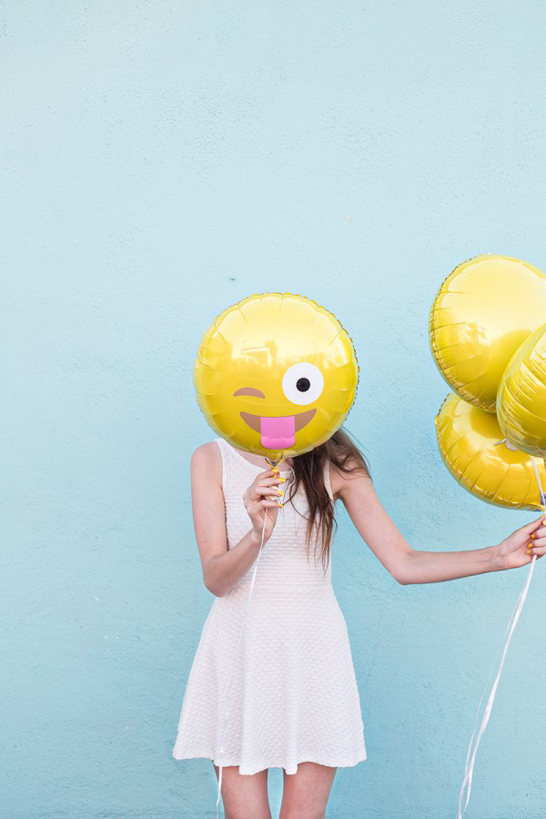Women Holding Smiling Face Emoji Balloon